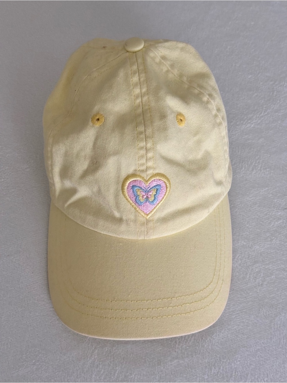 Yellow baseball cap with embroidered butterfly heart design